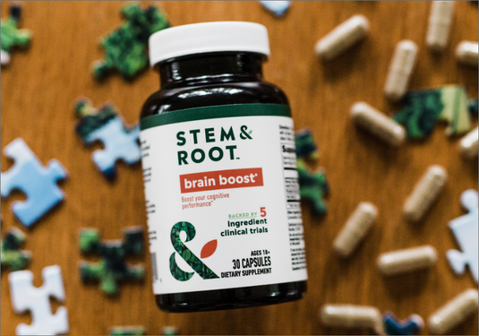 A bottle of Stem & Root Brain Boost on a table surrounded by puzzle pieces